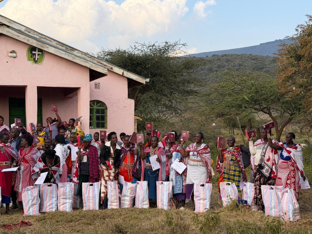 Women gathered outside a community building with supplies