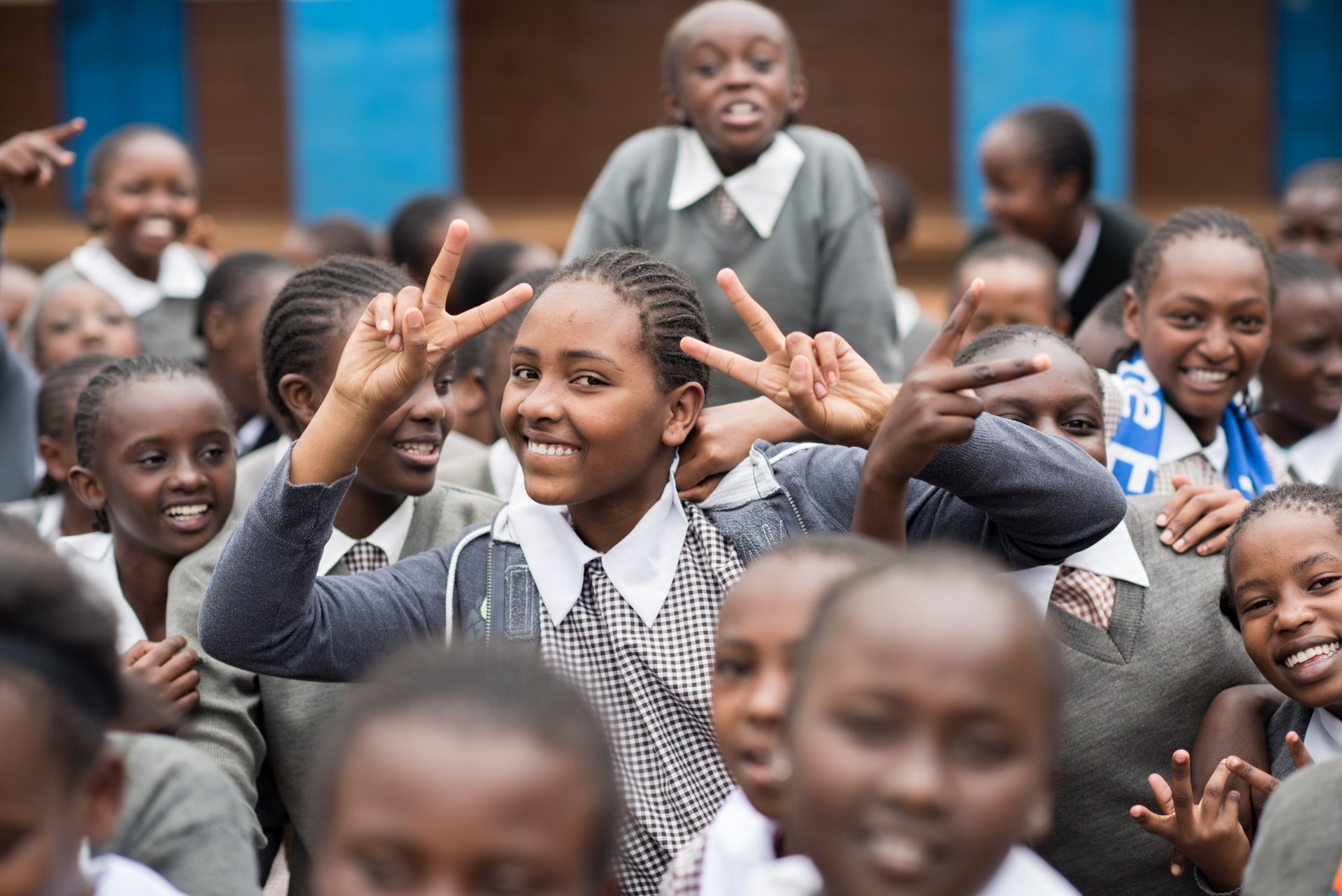 Smiling schoolchildren together, with a girl making peace signs